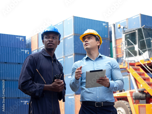 Foreman engineering african black skin male report businessman manager look notebook computer laptop tablet terminal warehouse technology shipper port logistic cargo list commercial container custom