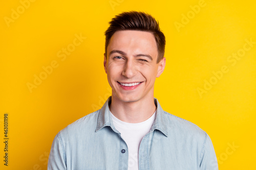 Portrait of young attractive handsome flirty man wink blink eye romance expression isolated on yellow color background