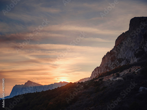 beautiful sunset in mountains, silhouettes of rocks and trees. Idea and concept of discovery, adventure, freedom of movement and relaxation