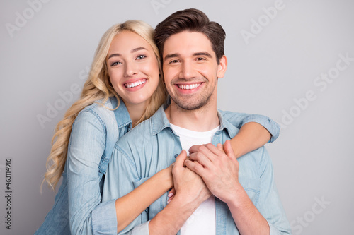 Portrait of attractive cheerful tender couple life partners hugging bonding isolated over gray pastel color background