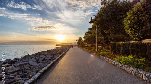 Walking Trail in a modern city on the West Coast of Pacific Ocean. West Vancouver Centennial Seawalk, British Columbia, Canada. Sunny Summer Sunset.