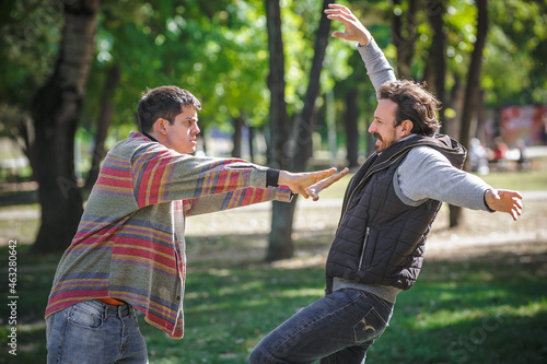 Nervous and upset man pushes another during aggressive quarrel conflict