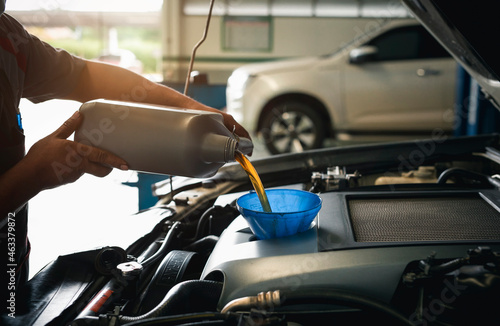 Close-up of mechanic in repairing car, change the oil at service center.