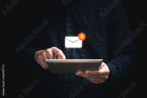 Businessman holding tablet and touching with virtual white newsletter for electronic mail or E-mail with notification alert concept.