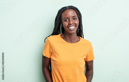 black pretty woman smiling cheerfully and casually with a positive, happy, confident and relaxed expression