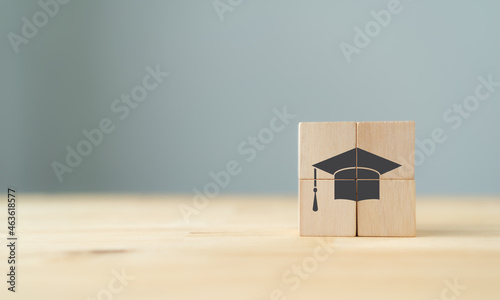 Graduation from university, education, diploma concept. Happiness cheerful feeling, Commencement, Graduation day. The wooden cubes with graduation cap on beautiful grey background and copy space.