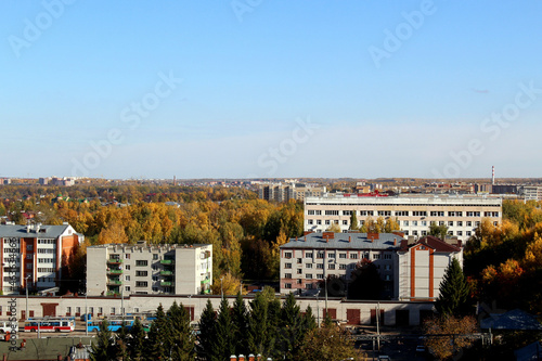 Autumn city on a sunny clear day. Yellow leaves on the trees. View from above.
