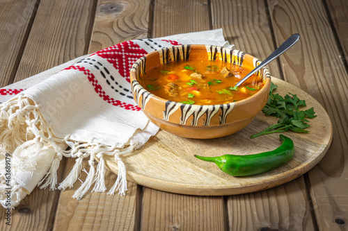 Romanian traditional beef soup served in clay bowl. In romanian is called "ciorba de vacuta".