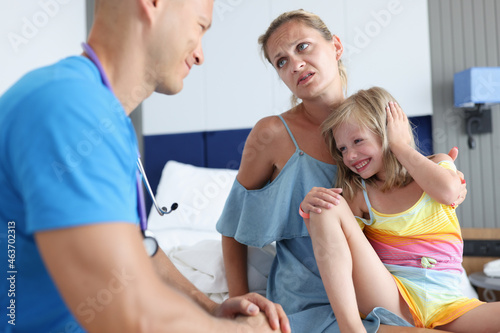 Young doctor communicates with woman little girl