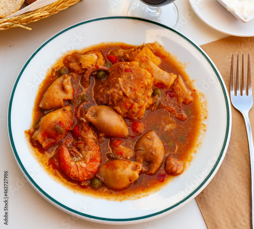 Traditional Spanish seafood zarzuela - stewed fish fillets, sea molluscs and crustaceans in thick sauce