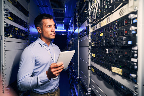 Concentrated tranquil system administrator inspecting networking equipment