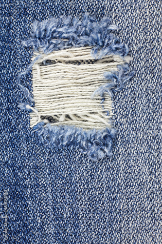 Denim torn blue jeans texture.