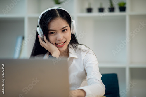 Online Education For Asian Young Women. Student Happy Arabic Girl In Headscarf And Headset Studying With Laptop At Home, Taking Notes While Watching Webinar