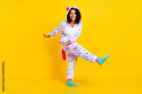 Full length body size view of pretty cheerful girl wearing funny pajama dancing isolated over bright yellow color background
