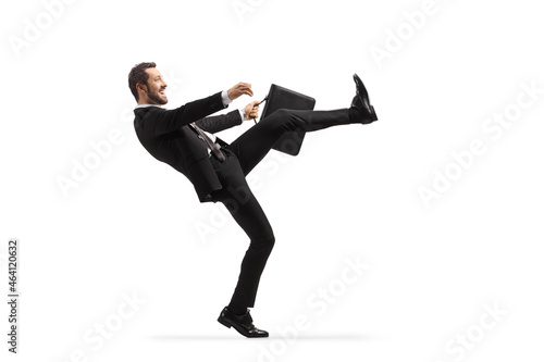 Full length profile shot of a businessman doing a silly walk