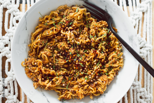 vegan ginger noodles with chilli flakes coriander seeds and tarragon herbs as topping, healthy plant-based food