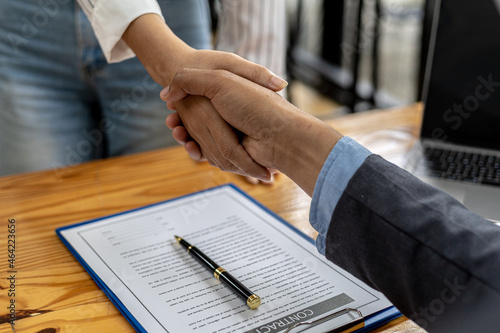 Two businesswomen shake hands after accepting a business proposal together, a handshake is a universal homage, often used in greeting or congratulations.