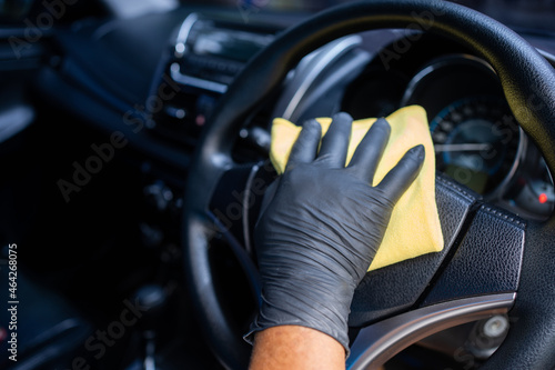 Man wearing gloves to clean the dashboard of the car. Auto Service.