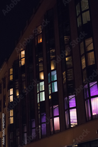 colorful lights in windows in a building block of flats apartments
