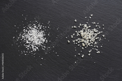 Two different types of traditional salt of high quality: the salt flower on the left and the coarse sel on the right on a black background. 