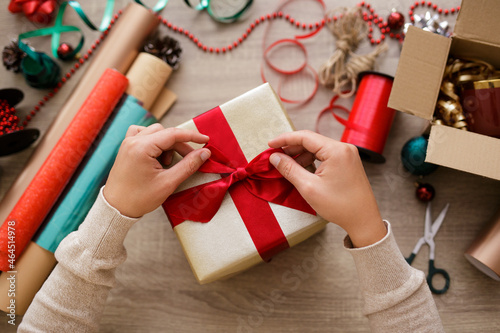 Close up of hands tying a bow on a gift