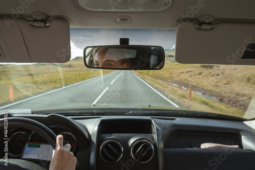 Female driver using navigation app while traveling to the destination through the Iceland