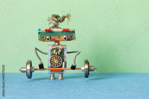 A toy robot weightlifter lifts a heavy steel barbell. strength weight training exercise. Sport fitness, weightlifting and power lifting athletics workouts.