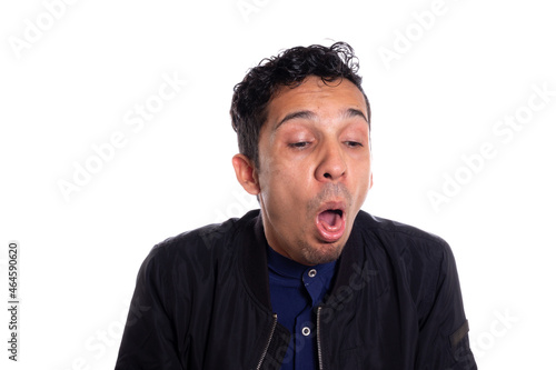 Disgusted man retching with vomit. White background. Young adult latin young man about to vomit from disgust. Face expressions.