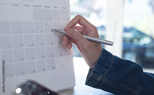 Event planner timetable agenda plan on schedule event. Business woman checking planner on mobile phone, taking note on calendar desk on office table