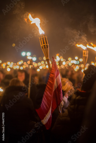 Latvian Lacplesa Day torchlight procession. Lighted torches with the Latvian flag