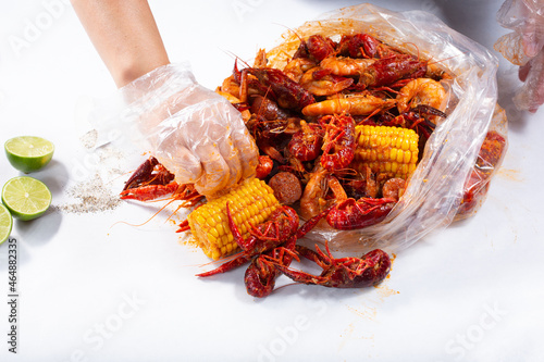 A view of hands opening a plastic bag full of seafood boil, at a local restaurant.