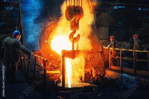 Process of casting in foundry, liquid molten metal pouring in ladle. Heavy metallurgy industry.