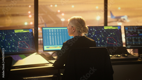 Portrait of Female Air Traffic Controller Working in Airport Tower. Office Room is Full of Desktop Computer Displays with Navigation Screens, Airplane Flight Radar Data.
