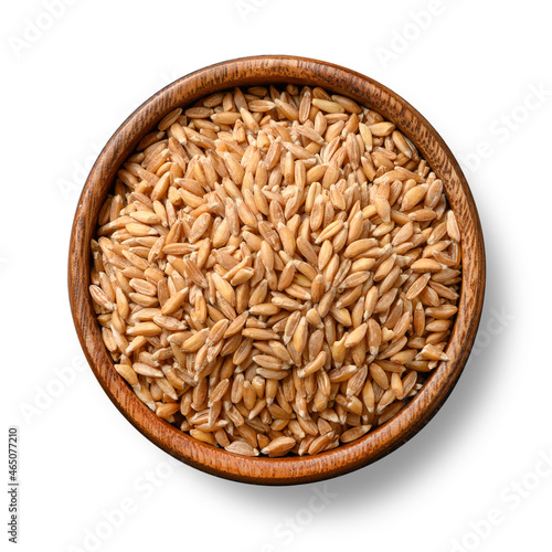 Wholegrain spelt farro in wooden bowl isolated on white background. View from above.