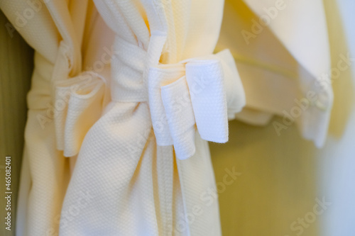 white bathrobe hanging in closet