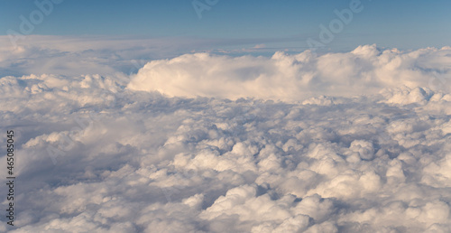 Stratosphere, a view of clouds from an airplane window. Cumuliform cloudscape on sky. Flying over the land.