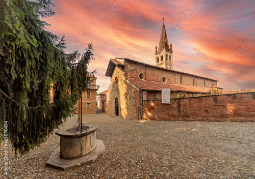 Saluzzo, Cuneo, Italy - October 19, 2021: The Church of San Giovanni (14th century), seat of the Servite Fathers in Via San Giovanni with ancient well and spectacular sky at sunset