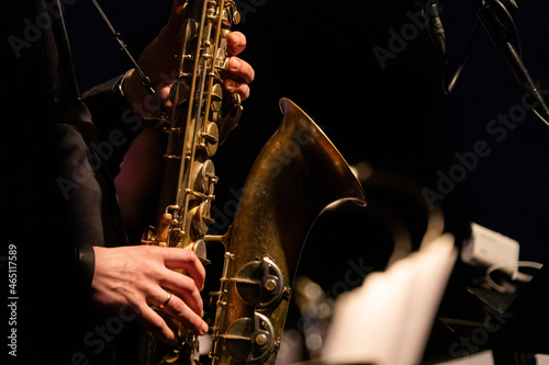 A tenor saxophone player playing a solo in front of a microphone during a live concert