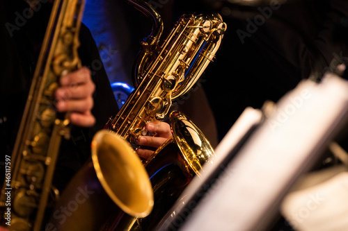 A baritone saxophone player getting his groove while playing in a sax section of a big band during a live concert performance