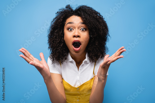 amazed african american woman with open mouth showing wow gesture isolated on blue