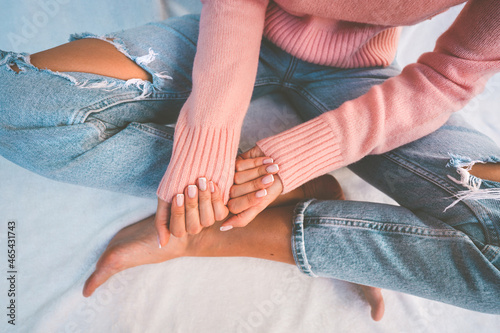 Stylish woman in pink sweater showing her french manicure nails. Female fingers with beautiful nails
