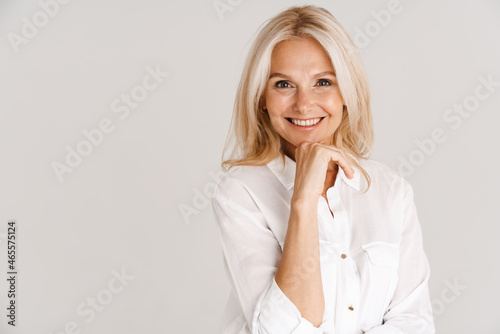Mature blonde woman wearing shirt smiling and looking at camera