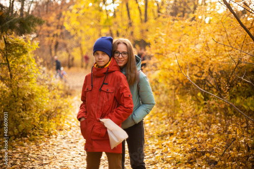 Autumn portrait of happy beautiful woman with her son on fall nature background
