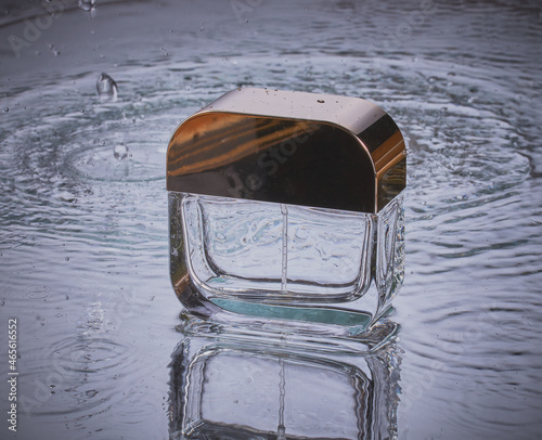 Perfume bottle isolated in water,with ripples and splash.
