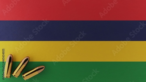 Three 9mm bullets in the bottom left corner on top of the national flag of Mauritius