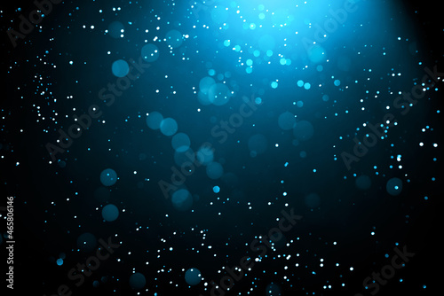 Abstract background with glowing turquoise particles.