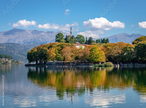 View of lake Pamvotis and the waterfront of the city of Ioannina, Greece, with the Old Castle and the Aslan Pasha Mosque. Reflections on the water in the autumn.