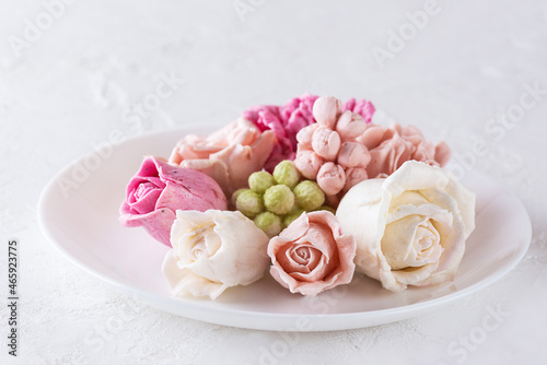 Multicolored zefir in the form of flowers on a plate.