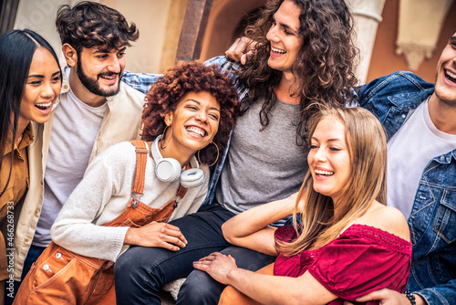 Multiracial group of friends laughing together outside - Multi ethnic young people having fun on city street - Happy students hanging out at university college - Youth and community concept