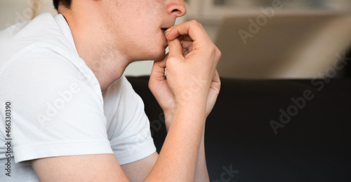 Young man feeling anxious and nervous biting nails